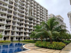 een groot appartementencomplex met een zwembad en palmbomen bij Estellar Resort Condotel in Manilla