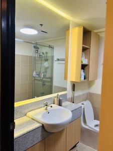 een badkamer met een wastafel en een toilet bij Estellar Resort Condotel in Manilla
