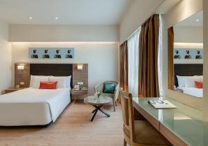 a hotel room with a bed and a desk at Greenpark Visakhapatnam in Visakhapatnam