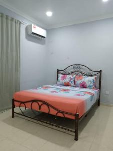 ein Schlafzimmer mit einem Bett mit einer roten Decke und Kissen in der Unterkunft Cempaka Homestay Batu Pahat 93 in Batu Pahat