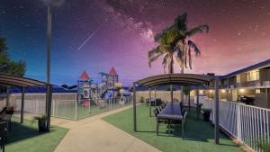 eine Darstellung eines Spielplatzes in der Nacht mit einem Schloss in der Unterkunft Coachman Hotel Motel in Parkes