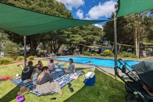 a group of people sitting on blankets by a pool at Tiny House 10 at Grampians Edge in Dadswells Bridge