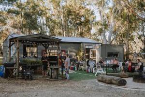 a group of people standing in front of a cabin at Tiny House 10 at Grampians Edge in Dadswells Bridge