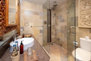 ウブドにあるAdiwana Svarga Loka - A Retreat Resortのバスルーム(洗面台、ガラス張りのシャワー付)
