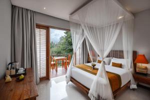 1 dormitorio con cama con dosel y balcón en Adiwana Svarga Loka - A Retreat Resort en Ubud