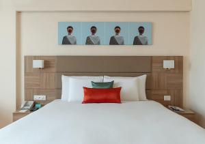 a bedroom with a large white bed with a red pillow at Greenpark Visakhapatnam in Visakhapatnam