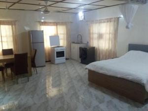 a bedroom with a bed and a kitchen and a desk at Limbas Luxury Appartements 2 in Bakau