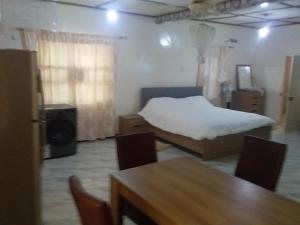 a bedroom with a bed and a table and chairs at Limbas Luxury Appartements 2 in Bakau