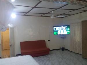 a room with a chair and a television on a wall at Limbas Luxury Appartements 2 in Bakau