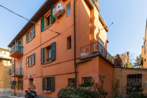 un edificio naranja con una motocicleta estacionada frente a él en Social Costa-Holiday & Business Apartment en Bolonia