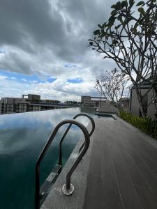 a swimming pool with a metal hand rail next to the water at Camelia Youth City Nilai Studio residence 5pax in Nilai