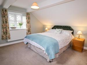 a bedroom with a large bed and a window at The Laurels Barn in Oswestry