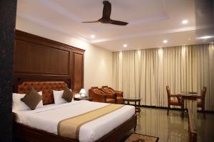 una camera d'albergo con letto e sedie e una camera di Hotel Bishnu Palace a Jhārsuguda