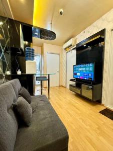 En tv och/eller ett underhållningssystem på 2BR Luxury Cozy Homestay With Mall Access Greenbay Apartment Baywalk