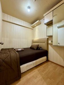a bedroom with a bed in the corner of a room at 2BR Luxury Cozy Homestay With Mall Access Greenbay Apartment Baywalk in Jakarta