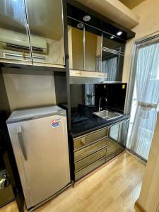 a small kitchen with a refrigerator and a sink at 2BR Luxury Cozy Homestay With Mall Access Greenbay Apartment Baywalk in Jakarta