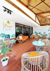 a room with wicker chairs and tables in a building at Puyo Suites Homestay in General Luna