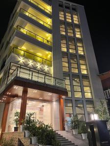 a tall building with lights on in the night at Hotel- The Yellow Queen in Guwahati