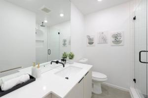 a white bathroom with a sink and a toilet at Seattle Charm, near university,3 BR,W&D, fast wifi in Seattle