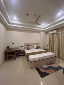 a bedroom with a large bed and a table at Hotel- The Yellow Queen in Guwahati