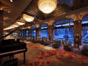 a hotel lobby with a piano and chairs and a restaurant at Kurofune Hotel in Shimoda