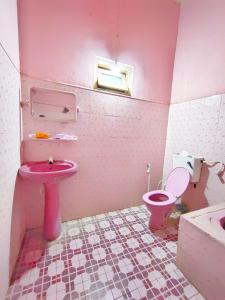 a pink bathroom with a toilet and a sink at SSM GUEST INN in Trincomalee