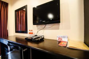 a room with a table with a television on a wall at FunDee Boutique Hotel in Patong Beach