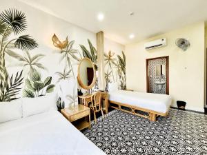 ホーチミン・シティにあるSpring House Saigon central parkのベッド2台と鏡が備わるホテルルームです。