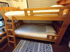 kilka łóżek piętrowych w pokoju w obiekcie Guesthome Machiya Koza w mieście Okinawa