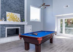 a living room with a pool table and a fireplace at Life Can Be A Beach in Galveston