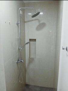 a shower with a glass door in a bathroom at Condotel810byWVtowers1&2 in Iloilo City