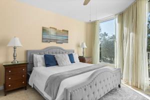 a bedroom with a large bed and a large window at Entire Condo - Palms of Destin Paradise in Destin