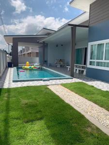 une arrière-cour avec une piscine et une maison dans l'établissement Grand Pool Villa Khonkaen เขื่อนอุบลรัตน์, 