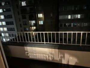 - un balcon avec vue sur certains bâtiments la nuit dans l'établissement Luxus Apartment in Center Dusseldorf - 2 Rooms, à Düsseldorf