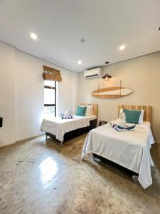 Habitación con 2 camas en una habitación en Siargao Bed and Brewery en General Luna