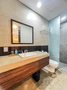 bagno con lavandino, servizi igienici e specchio di Siargao Bed and Brewery a General Luna