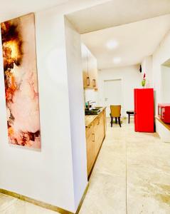 kuchnia z białymi ścianami i czerwoną lodówką w obiekcie YS Apartments e.U. w mieście Marchtrenk