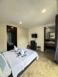 een slaapkamer met een groot wit bed en handdoeken bij Siargao Bed and Brewery in General Luna