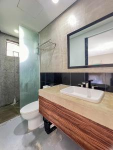 uma casa de banho com um lavatório, um WC e um espelho. em Siargao Bed and Brewery em General Luna