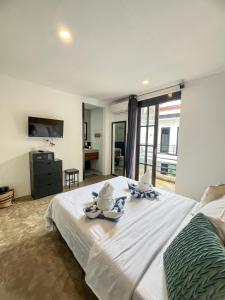 a bedroom with a large white bed and a large window at Siargao Bed and Brewery in General Luna