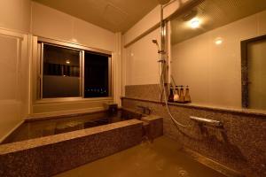 a wet bathroom with a shower and a window at Oita Onsen Business Resort Kyuan - Vacation STAY 50131v in Oita