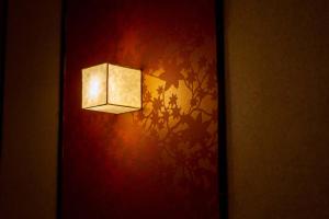a light on a wall with a red wall at RESI STAY Fuyacho in Kyoto
