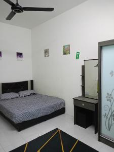 - une chambre avec un lit et une télévision à écran plat dans l'établissement hayfa homestay private pool ipoh, à Ipoh