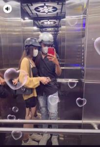 a man and a woman wearing helmets in a mirror at Homeatay & Apartment CHÂU SƠN in Vung Tau