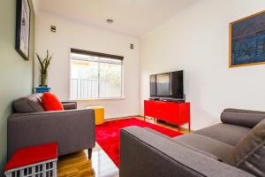 a living room with two couches and a television at Indulge Homes - 77 Olive in Mildura