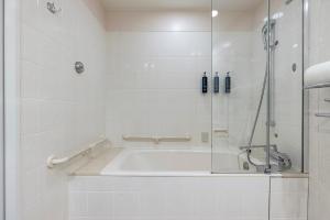 a bathroom with a tub and a glass shower at Hilton Odawara Resort & Spa in Odawara