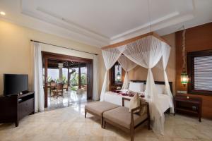 a bedroom with a bed with a canopy at The Club Villas Seminyak in Seminyak