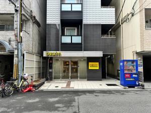 a building with a sign on the front of it at CHECKinn Osaka Shinimamiya in Osaka