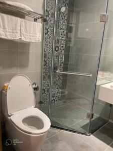 ein Bad mit einem WC und einer Glasdusche in der Unterkunft Anna House Homestay in Kim Quan