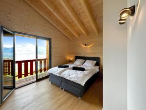 een slaapkamer met een bed en een groot raam bij My Mountain Paradise - Swiss Alps in Rechy